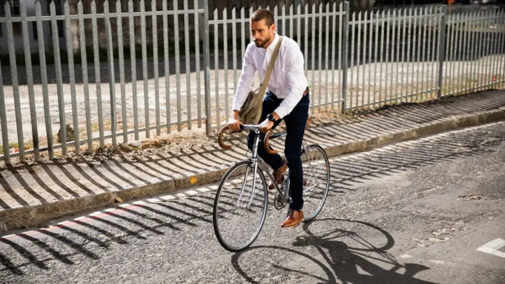 Young man riding a vintage steel bicycle on a city street, reflecting sustainable urban commuting and Gen Z’s analog lifestyle revival